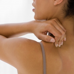 woman rubbing own shoulder